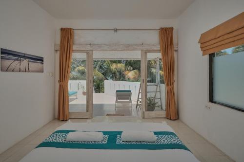 Jereweh米娅莫海滩酒店的一间卧室配有一张床,享有庭院的景色