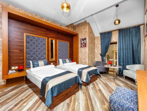 巴库Manor Luxury Hotel Baku的酒店客房,设有两张床和一张沙发