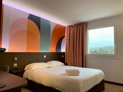 圣阿沃尔德B&B HOTEL Saint-Avold Nord的一间卧室配有一张带彩色墙壁的床