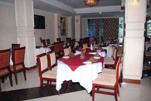 阿克苏姆Yaredzema International Hotel的餐厅内带桌椅的用餐室