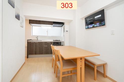 东京Downtown Apartment/ SHIBUYA Station 10mins on foot的一个带木桌和椅子的小厨房