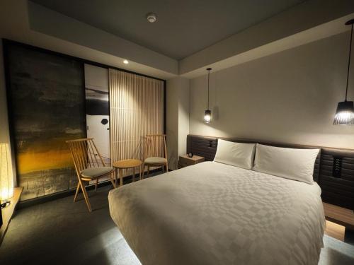 大阪Hotel Resol Trinity Osaka的一间卧室配有一张床和两把椅子