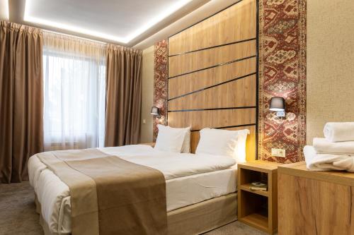 韦林格勒SPA Hotel Olymp的一间设有大床和窗户的酒店客房