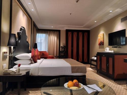 班加罗尔圣马可酒店 的酒店客房,配有一张床和一张桌子,还有一碗水果
