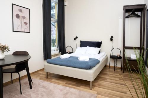 奥斯陆Grünerløkka Deluxe Apartments的一间卧室配有一张床、一张桌子和一张桌子