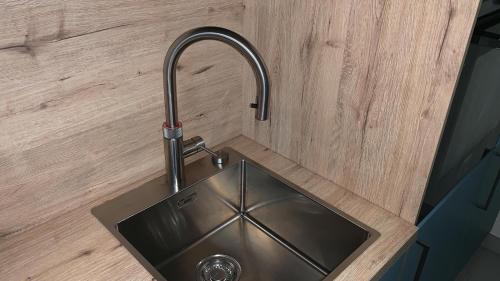 诺德代希Seeblick 3的木墙上带水龙头的厨房水槽