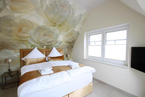 诺德代希Seeblick 3的卧室配有一张挂着花壁画的床。