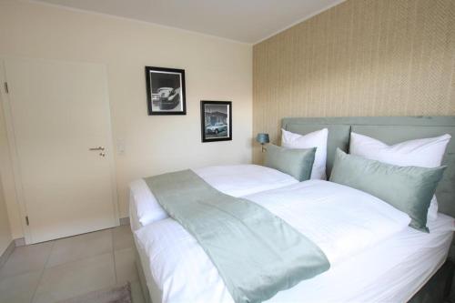 诺德代希Seeblick 5 - Luxus am Hafen的卧室配有一张带白色床单和枕头的大床。