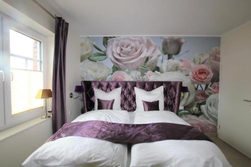 诺德代希Seeblick 7的一间卧室配有一张带花卉墙壁的床