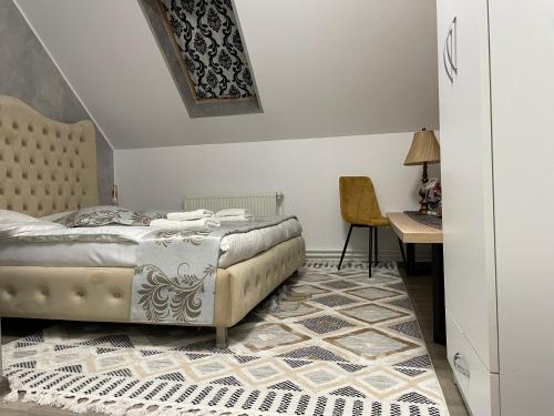 瓦马Casa cu Pitici的一间卧室配有一张床、一张桌子和一把椅子