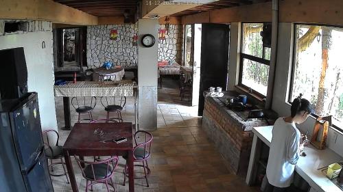 迦太基Reserva y Estancia Robles Mimosos Lodge的站在带桌椅的厨房中的女人