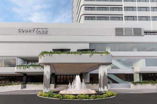 普吉镇Courtyard by Marriott Phuket Town的建筑物前方有喷泉的建筑物