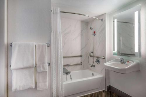 萨克拉门托北萨克拉门托拉昆塔旅馆的白色的浴室设有水槽和浴缸。