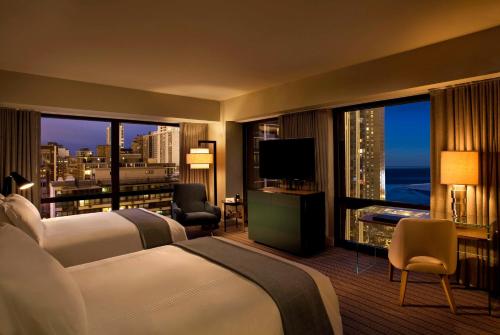 芝加哥Thompson Chicago, by Hyatt的酒店客房设有两张床和大窗户。