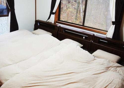 SaikuboSunland S45 - Vacation STAY 45835v的窗户客房内的一张白色床