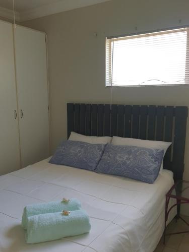 比勒陀利亚Jean Michael Self-catering apartment for stay overs的床上有蓝色毛巾