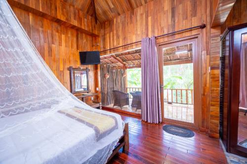 富国Chez Carole Beach Resort Phu Quoc的卧室配有一张床铺,位于带木墙的房间内