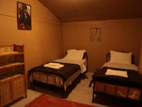 AdrouineTamaris Camp的一间设有两张床的房间,其中有一个架子