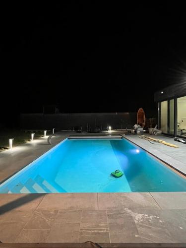 穆斯克龙Villa piscine chauffée, jacuzzi et sauna的夜间大型蓝色游泳池