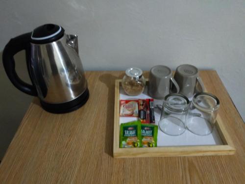RomblonSea u inn的餐桌、咖啡壶和带玻璃杯的托盘