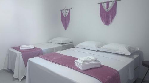 伦索伊斯Pousada Estrelar的紫白色客房的两张床