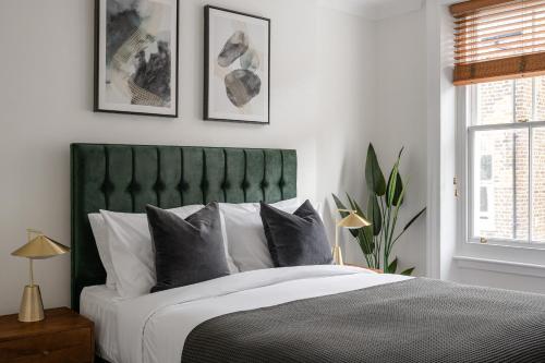 伦敦Urban Rest Notting Hill Apartments的一间卧室配有一张大床和绿色床头板