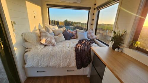 KillarneyCoastal Sunset Tiny Home - Port Fairy Tiny Homes的一个小房间的一个床位,设有窗户