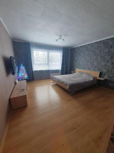 萨拉斯皮尔斯Salaspils Apartament 2023的一间卧室,配有一张床,里面有一棵圣诞树