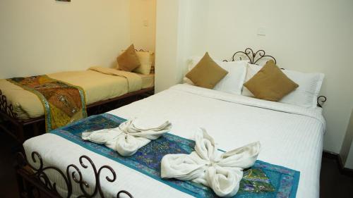 巴克塔普尔Cosy Hotel的一间卧室配有两张带毛巾的床