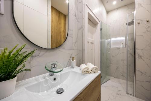 布达佩斯Luxurious Central 4BEDRM 3BATHRM Residence w/ Balcony的白色的浴室设有水槽和镜子