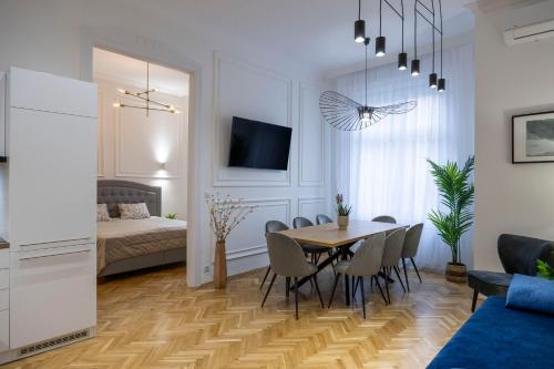 布达佩斯Luxurious Central 4BEDRM 3BATHRM Residence w/ Balcony的用餐室以及带桌椅的起居室。