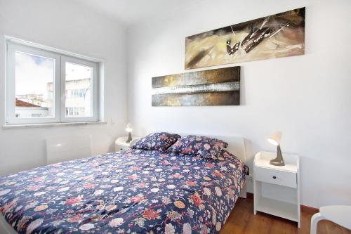 卡尔达斯达·赖尼亚Apartamento da Alegria的卧室配有一张床,墙上挂有两幅画