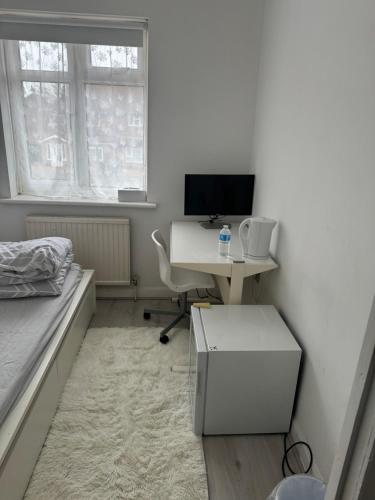 CanveySingle Room的一间卧室配有一张桌子、一台电脑和一张床