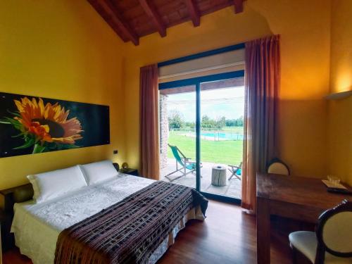 Marmirolo科尔特狂欢节农庄酒店的一间卧室设有一张床和一个滑动玻璃门