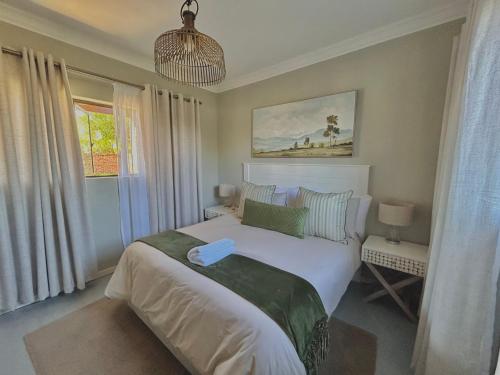 波罗瓜尼The Acorn @ Skyfall Country Estate的卧室设有一张白色大床和一扇窗户。