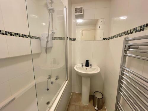 谢菲尔德Vibrant Loft Apartment in Grade II Listed Georgian Building的白色的浴室设有水槽和淋浴。