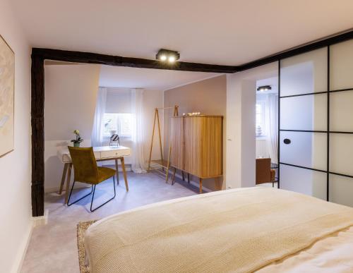 拜罗伊特Romantisches Apartment mit Whirlpool in Bayreuther Fußgängerzone的一间卧室配有一张床、一张桌子和一张桌子