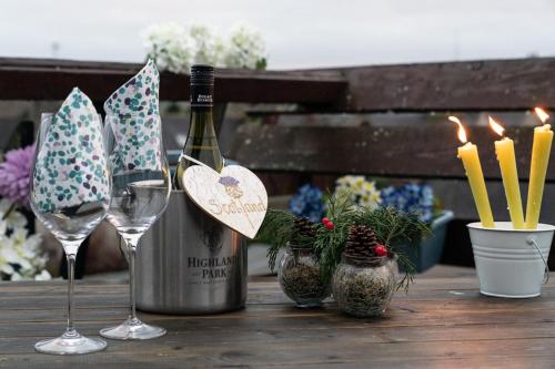 亨特利Dunedin House -Contractors - Business Travellers的木桌旁的一瓶葡萄酒和两杯酒