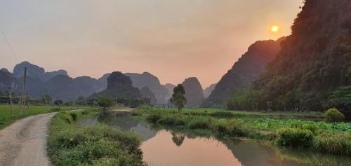 Nguyên NgoạiNice homestay in Ninh Binh的一条有泥土路和山地的河流