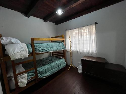 瓦努科Casa San Lorenzo的客房设有两张双层床和一扇窗户。