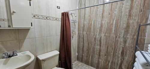 阿瓜达Discovery Beach Apartments的带淋浴、卫生间和盥洗盆的浴室