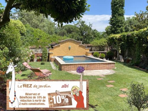 阿尔比Le Rez de Jardin Albi的一个带游泳池的院子内的标志