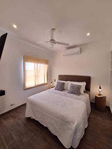 费德拉西翁Los Carpinchos: Duplex的卧室配有白色的床和窗户。