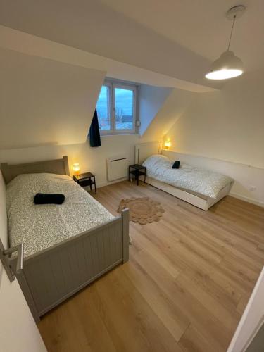 MouvauxMaison familiale 3 chambres avec terrasse的铺有木地板的客房内的两张床