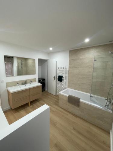 MouvauxMaison familiale 3 chambres avec terrasse的白色的浴室设有浴缸和水槽。