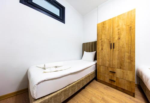 伊斯坦布尔Mia Mia Suites的一间卧室配有一张床和一个木制橱柜