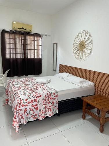 萨尔瓦多Pousada hostel praia itapua的一间卧室配有一张带红白毯子的床