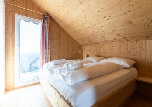 克利浦托尔1A Chalet Eck - Wandern und Grillen, Panorama Sauna!的木制客房的一张床位,设有窗户