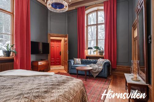 TimråMerlo Slott的一间卧室配有红色窗帘、一张床和一张沙发