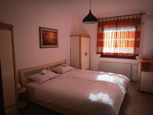 Loče pri PoljčanahHiša Žičanka的一间卧室配有带两个枕头的床和窗户